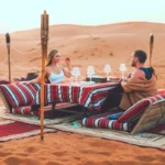 man and woman sitting at table in private desert safari dubai tour