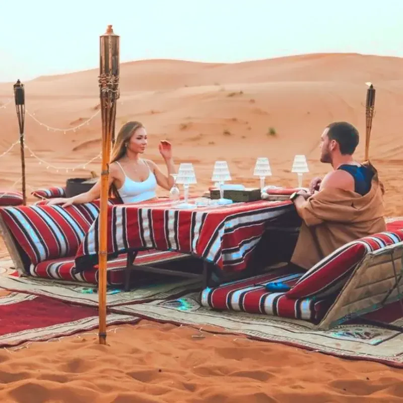 man and woman sitting at table in private desert safari dubai tour