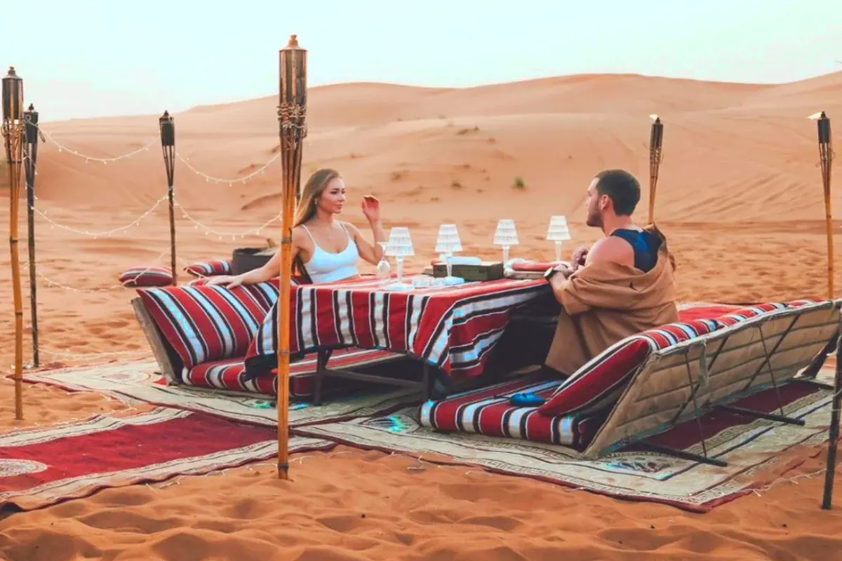 man and woman sitting at table in private desert safari dubai tour
