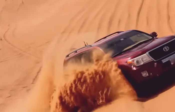 Landcruiser roaring up on hill in Dubai desert