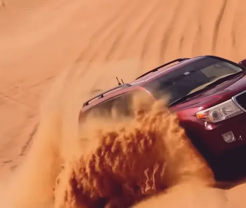 Landcruiser roaring up on hill in Dubai desert