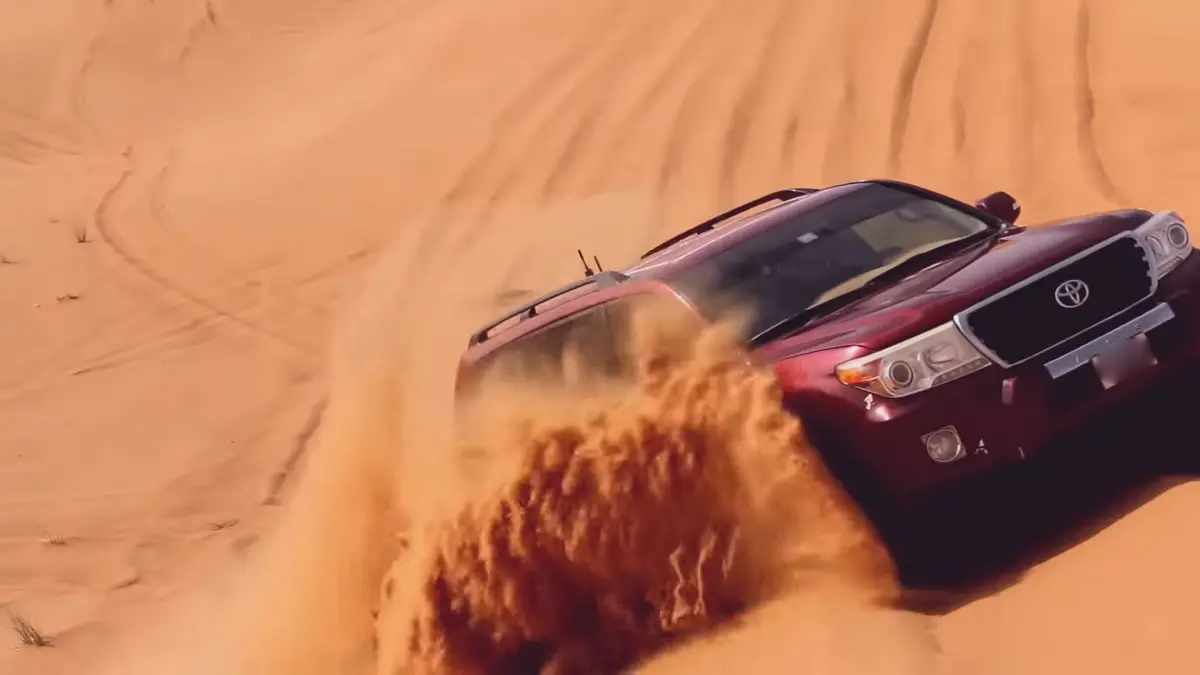 Landcruiser roaring up on hill in Dubai desert